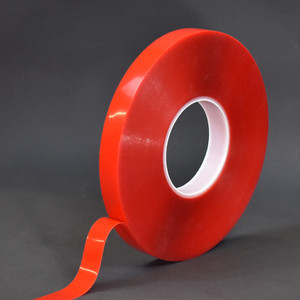Roll of clear high bond tape partially unwound on red liner