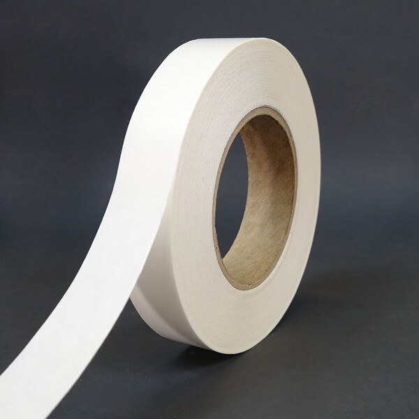 Single roll of double sided tape unwound to show white polyester liner