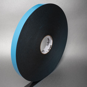 A standing roll of double sided black foam tape with a blue liner in front of grey background