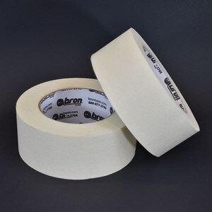 Two rolls of beige general purpose masking tape on black background