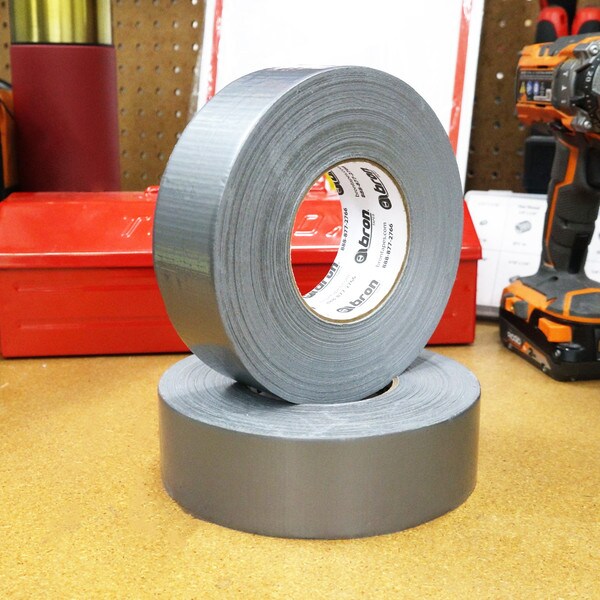 Heavy duty duct tape stacked on work bench in front of red tool box