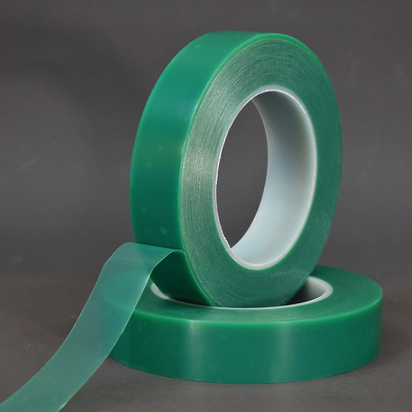 Two rolls of green protective film stacked in front of black background