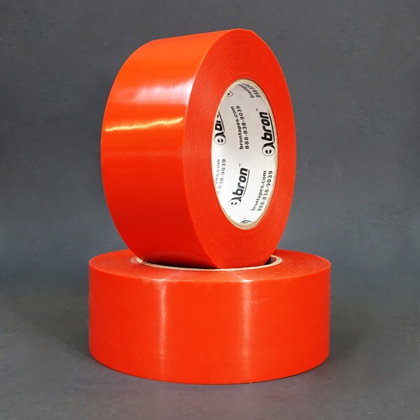 Two rolls of red polyethylene tape stacked in front of grey background