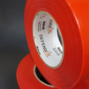 Roll of red pinked edge polyethylene tape up close