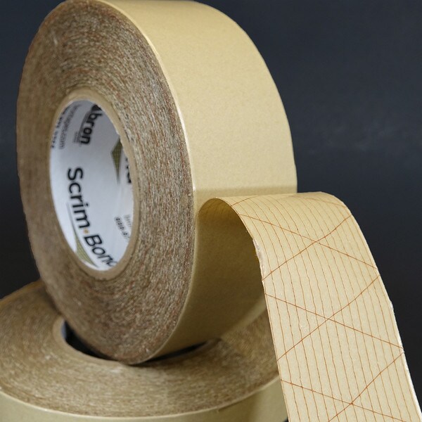 Roll of Scrim-Bond partially unwound to show red scrim in adhesive
