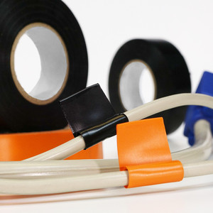 Black and orange electrical tape being used to create color coded tabs on cables